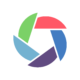 A circular logo made of five coloured segments—green, red, dark blue, purple, and light blue—arranged like a camera shutter on a white background, symbolising energy efficiency and sustainability strategy.